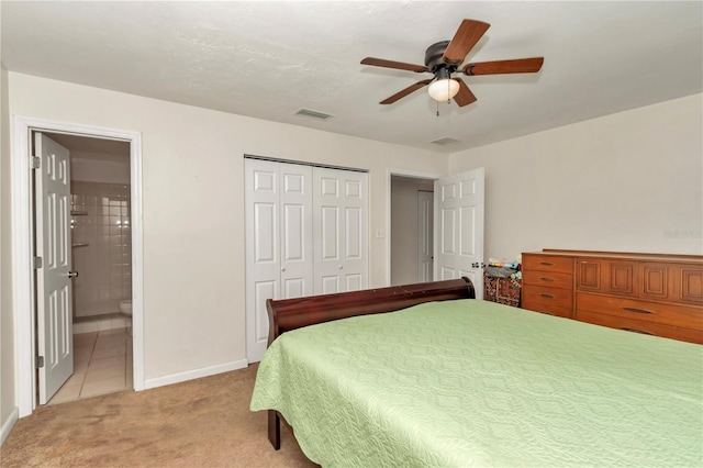 carpeted bedroom with ceiling fan, ensuite bath, and a closet