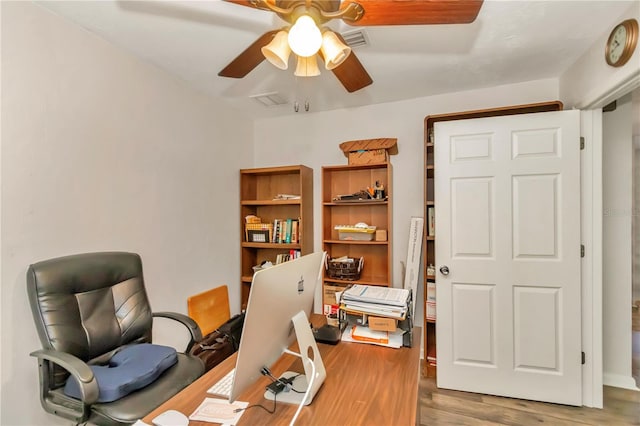 home office with light hardwood / wood-style floors and ceiling fan