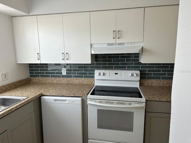 kitchen with tasteful backsplash, white cabinets, and white appliances