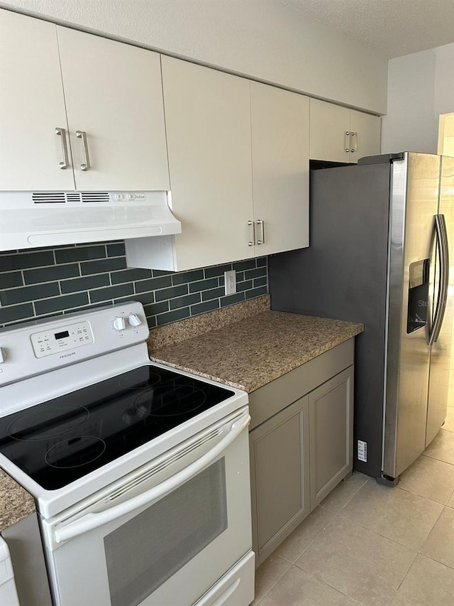 kitchen with tasteful backsplash, a textured ceiling, light tile patterned floors, stainless steel fridge, and white electric stove