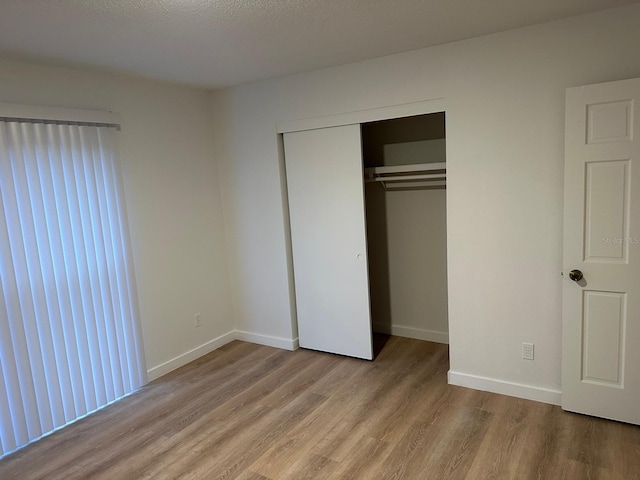 unfurnished bedroom featuring light hardwood / wood-style floors and a closet