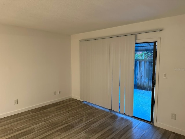 unfurnished bedroom featuring dark hardwood / wood-style floors, a closet, and a textured ceiling