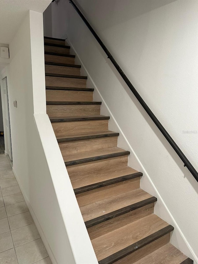 stairway with tile patterned floors