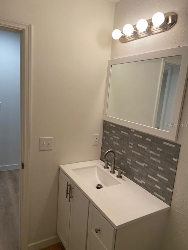 bathroom featuring vanity and decorative backsplash