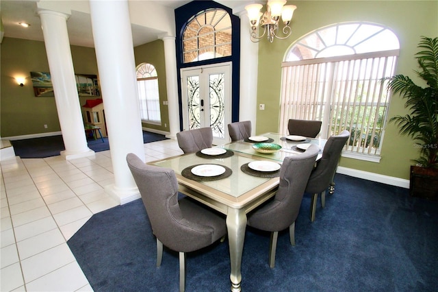 tiled dining room featuring french doors, a chandelier, and ornate columns