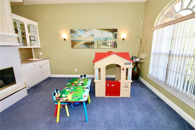 playroom with dark colored carpet and sink