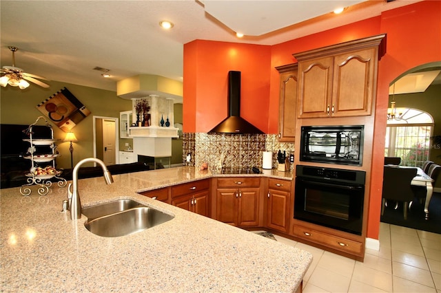 kitchen featuring wall chimney exhaust hood, sink, tasteful backsplash, light stone countertops, and black appliances