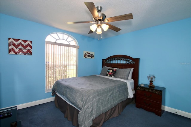 bedroom featuring a textured ceiling, ceiling fan, and dark colored carpet