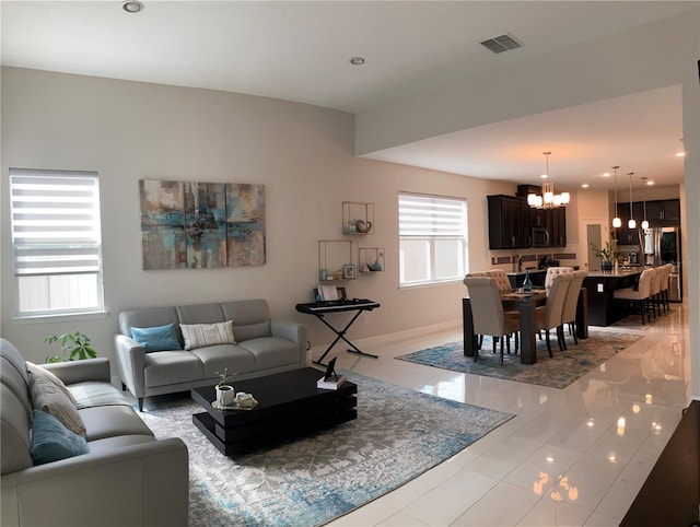 tiled living room featuring a healthy amount of sunlight and a chandelier