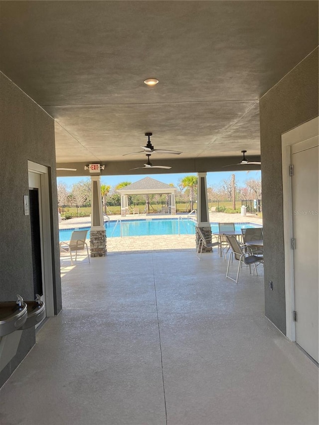 view of patio / terrace with a gazebo, ceiling fan, and a community pool