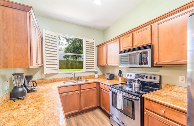 kitchen featuring sink, light hardwood / wood-style floors, and appliances with stainless steel finishes