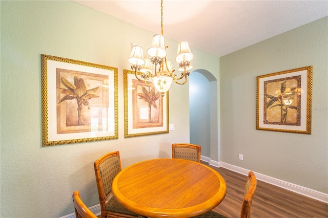 dining area with hardwood / wood-style floors and a notable chandelier