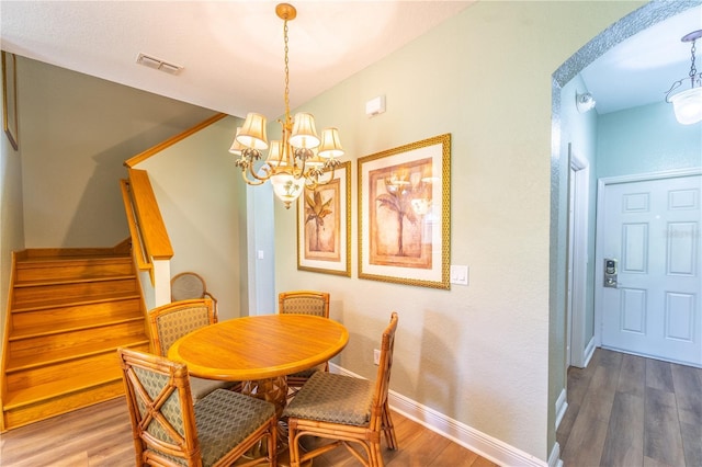 dining room featuring dark hardwood / wood-style flooring and a chandelier