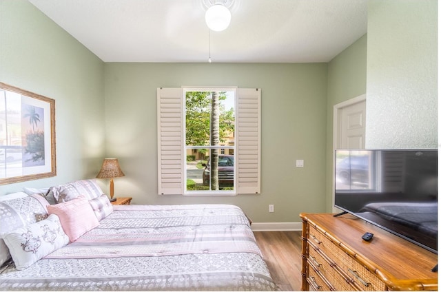 bedroom with ceiling fan and light hardwood / wood-style floors