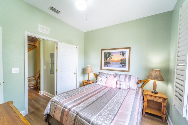 bedroom featuring electric panel and hardwood / wood-style floors