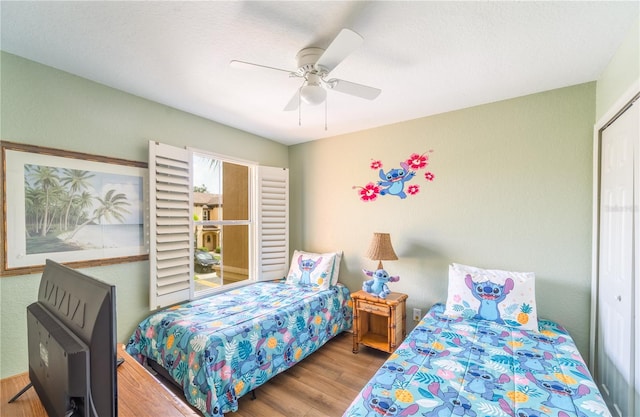 bedroom featuring hardwood / wood-style flooring, ceiling fan, and a closet