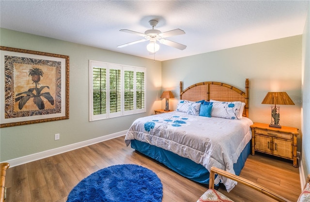 bedroom featuring wood-type flooring, a textured ceiling, and ceiling fan