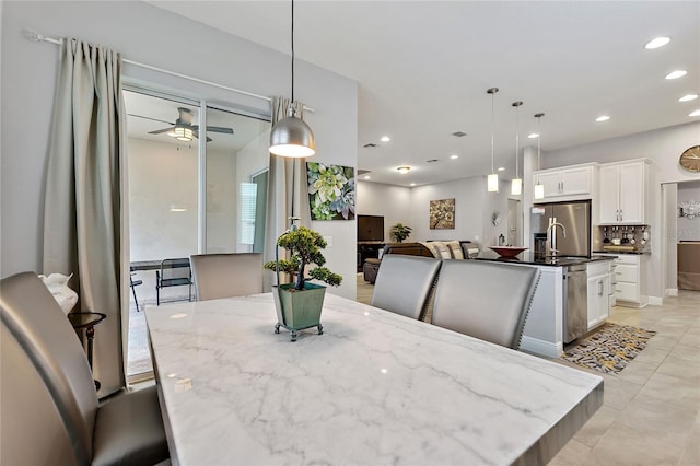 dining room with light tile patterned flooring, sink, and ceiling fan