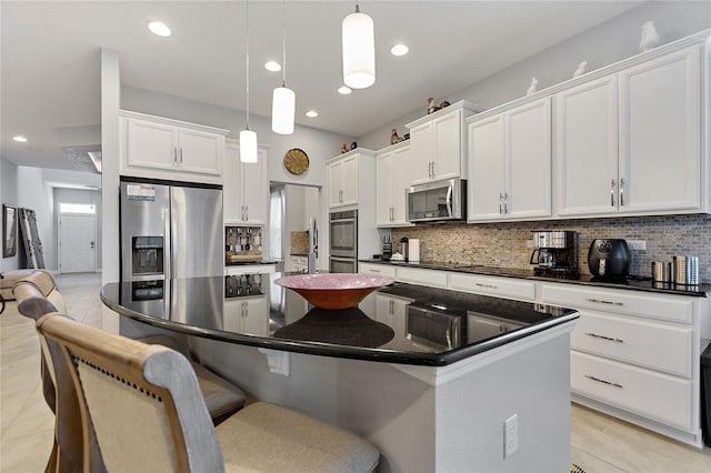 kitchen with a kitchen island, white cabinetry, appliances with stainless steel finishes, and hanging light fixtures