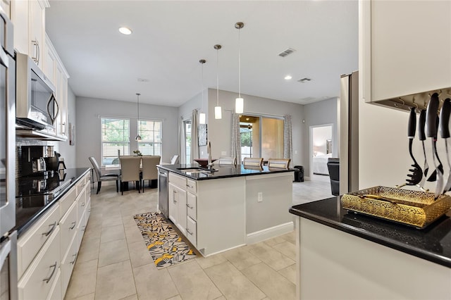 kitchen featuring sink, appliances with stainless steel finishes, white cabinetry, hanging light fixtures, and a center island