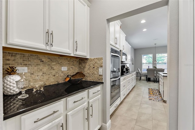 kitchen with white cabinetry, stainless steel appliances, and tasteful backsplash