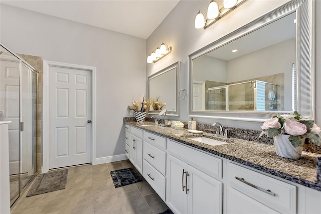 bathroom with a shower with door, vanity, and tile patterned floors