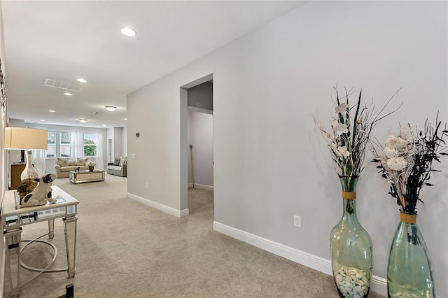 hall featuring light colored carpet