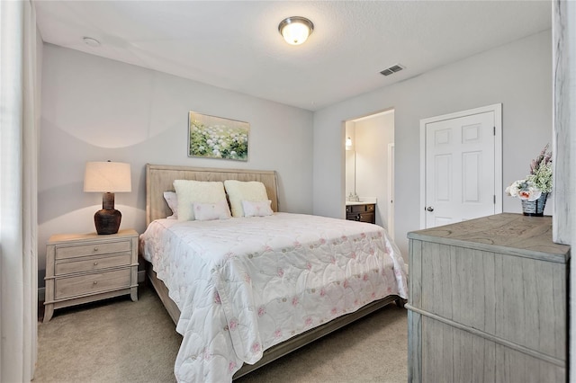 carpeted bedroom with ensuite bath