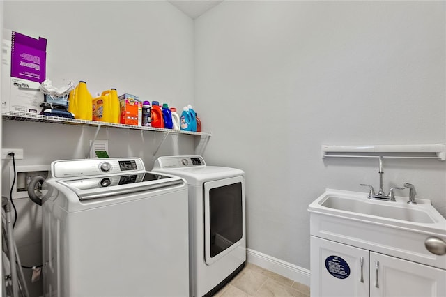 laundry area with cabinets, separate washer and dryer, sink, and light tile patterned floors