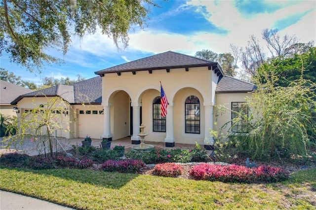 mediterranean / spanish house with a garage and a front lawn