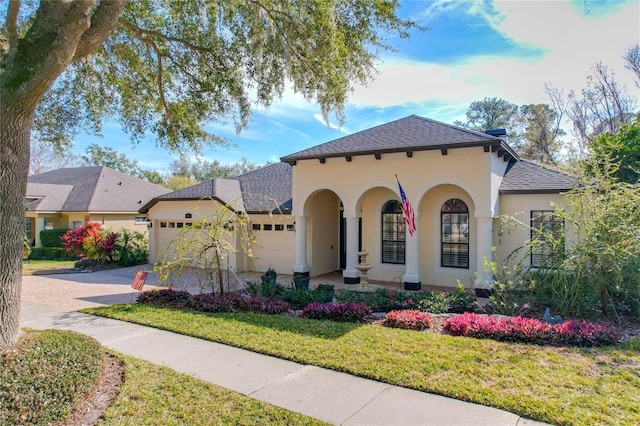 mediterranean / spanish-style home featuring a garage and a front lawn