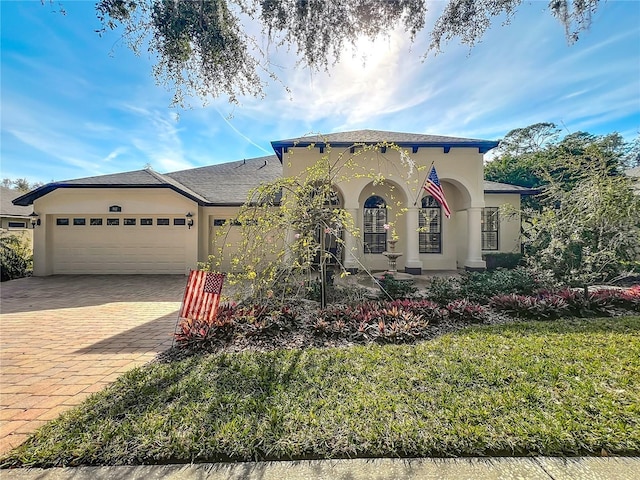 mediterranean / spanish-style home featuring a garage and a front yard