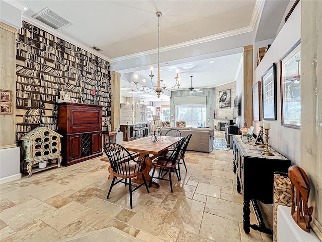 dining room with crown molding, a large fireplace, and a chandelier