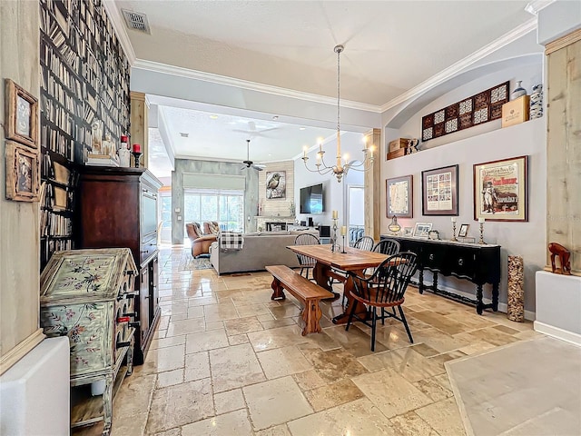 dining area featuring crown molding and ceiling fan with notable chandelier