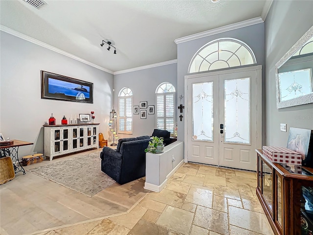 entryway with ornamental molding and french doors