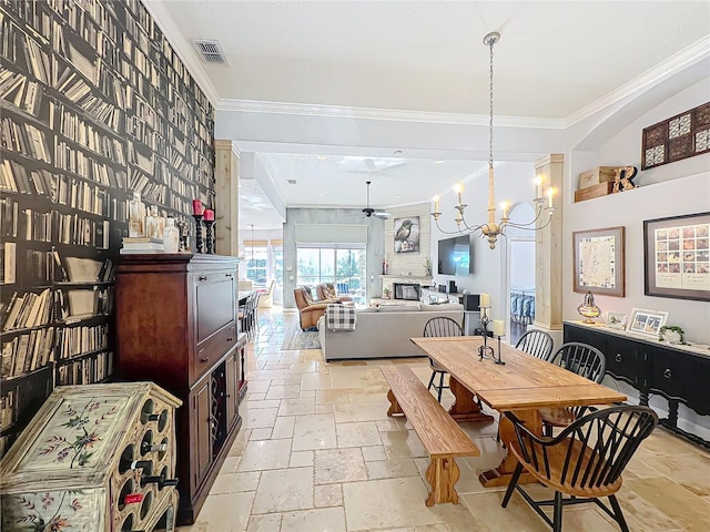 dining area featuring crown molding and ceiling fan with notable chandelier