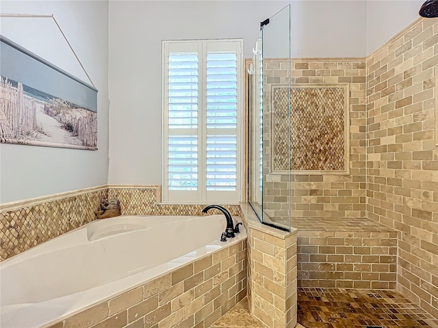 bathroom featuring independent shower and bath and a healthy amount of sunlight