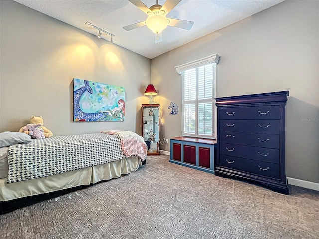 bedroom with ceiling fan, track lighting, a textured ceiling, and carpet