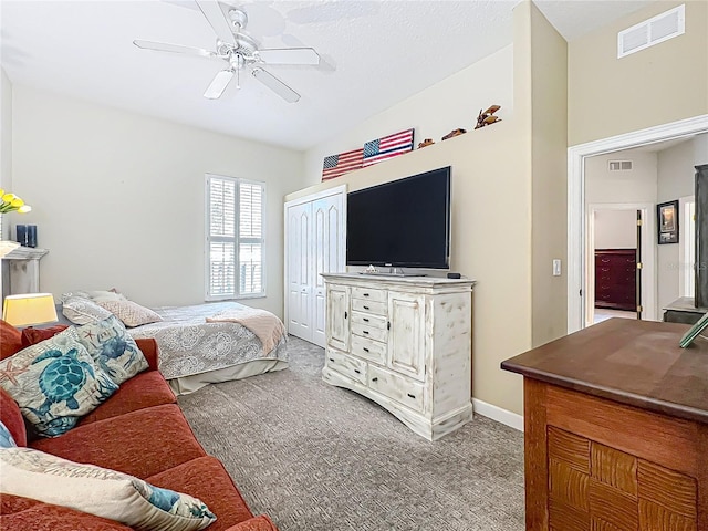 carpeted bedroom featuring ceiling fan and a closet