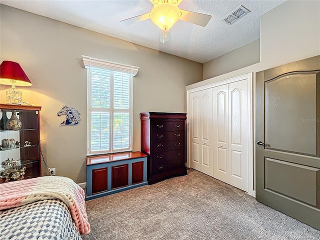 bedroom with ceiling fan, carpet floors, a textured ceiling, and a closet