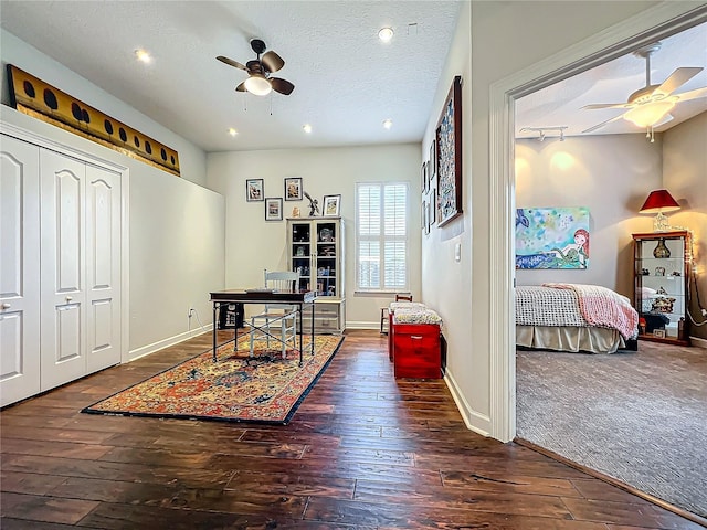 office area with dark wood-type flooring, a textured ceiling, and ceiling fan