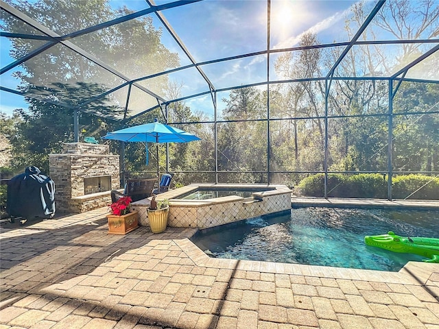 exterior space with a patio, a lanai, an in ground hot tub, and an outdoor stone fireplace