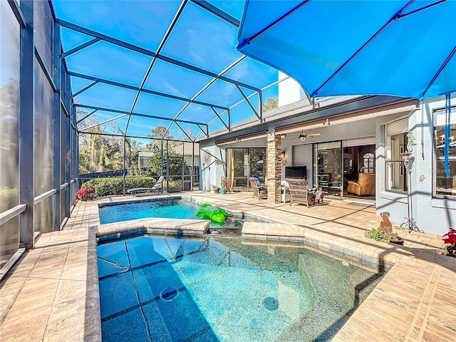 view of swimming pool featuring an in ground hot tub, a lanai, ceiling fan, and a patio area