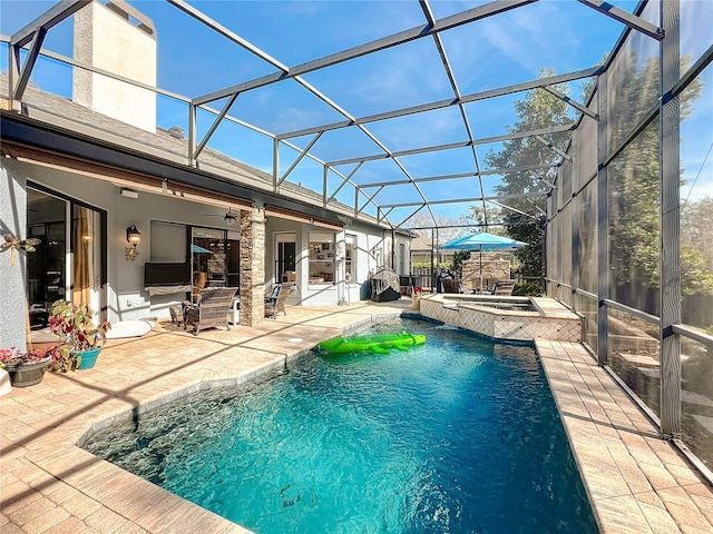 view of pool with ceiling fan, a patio area, glass enclosure, and an in ground hot tub