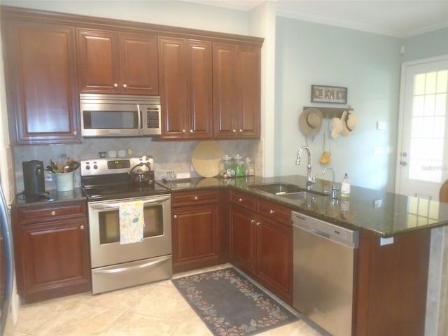 kitchen with sink, crown molding, appliances with stainless steel finishes, dark stone countertops, and kitchen peninsula