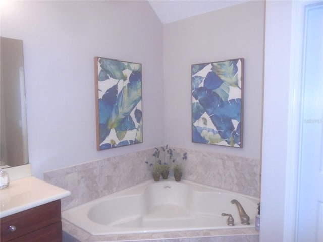 bathroom featuring a relaxing tiled tub and vanity