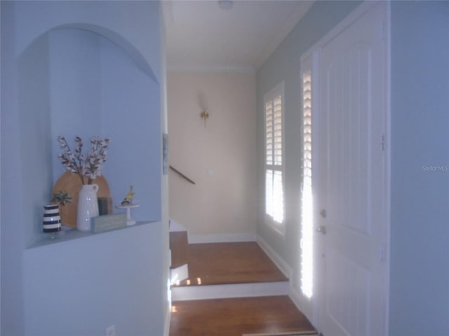 stairway with hardwood / wood-style floors and crown molding