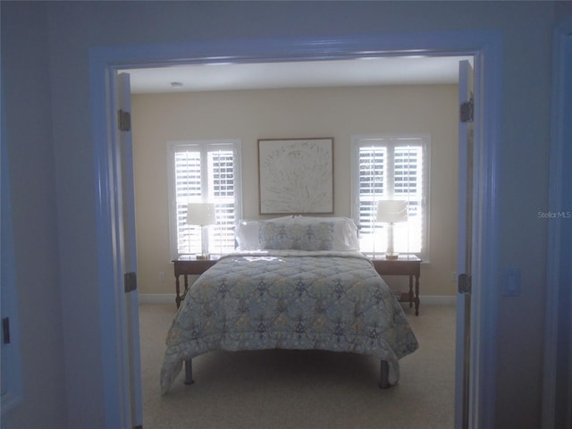 bedroom with multiple windows and carpet