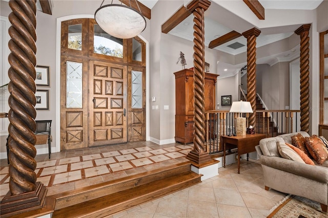 entrance foyer featuring decorative columns, light tile patterned floors, ornamental molding, baseboards, and stairs