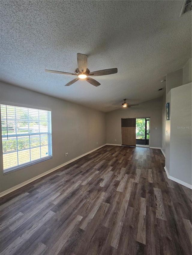 empty room with dark hardwood / wood-style flooring and a textured ceiling